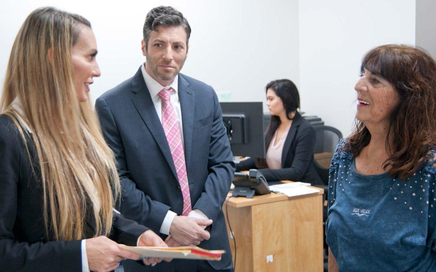 Steve Deitsch and Kerri Wright speaking with a client in an office